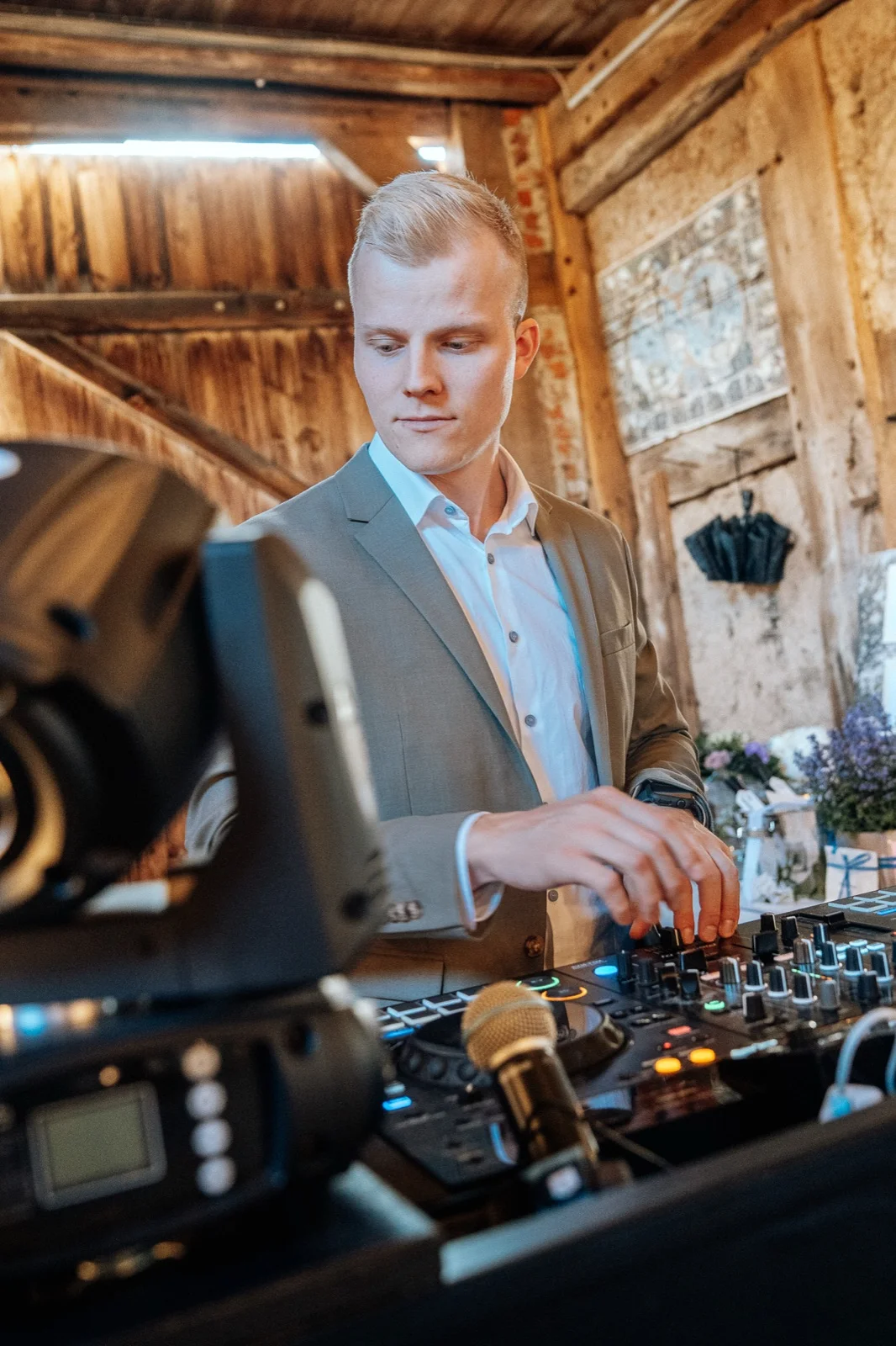 Cedric Callan im hellen Anzug an seinem DJ-Pult bei einer Hochzeit