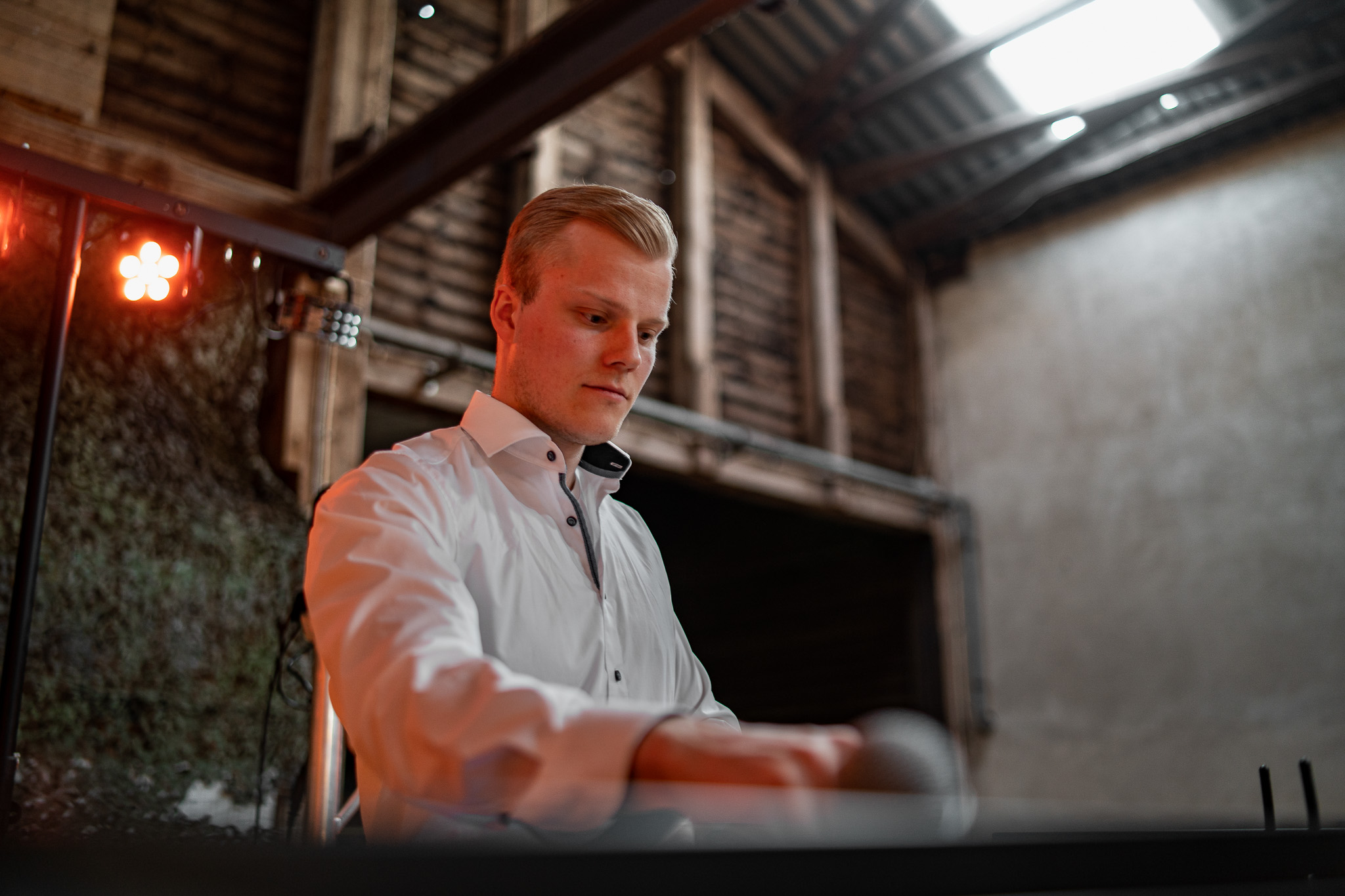 DJ Cedric Callan in Hemd am Mischpult auf einer Hochzeit